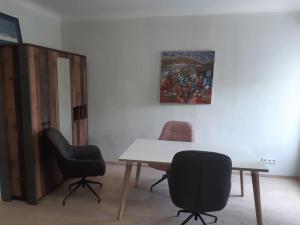 a room with a table and two chairs and a painting at Stadtresidenz Salburg in Klagenfurt