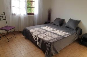 1 dormitorio con 1 cama, 1 silla y 1 ventana en Villa Montady, en Montady