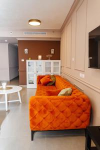an orange couch in a room with a table at Стильные апартаменты Dotan in Netanya