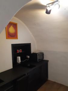 een kamer met een zwart bureau en een magnetron bij Stadtresidenz Salburg in Klagenfurt