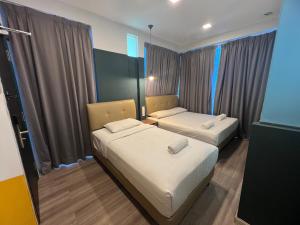 a small room with two beds and curtains at Smile Hotel Subang Airport in Shah Alam