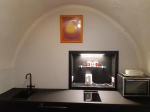 a room with a sink and a microwave and a tv at Stadtresidenz Salburg in Klagenfurt