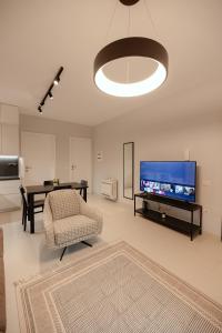 a living room with a tv and a chair and a table at Babbo in Vlorë