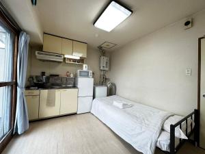 - une petite cuisine avec un lit dans une chambre dans l'établissement Hokusei Bldg 42 ほくせいビル 42号室, à Sapporo