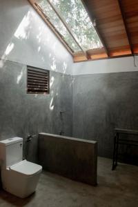 a bathroom with a toilet and a bath tub at Mambo’s hotel Arugam Bay in Pottuvil