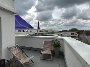 2 Stühle auf dem Balkon in der Unterkunft Ostwall Terrassen Apartment 5.29 in Bocholt