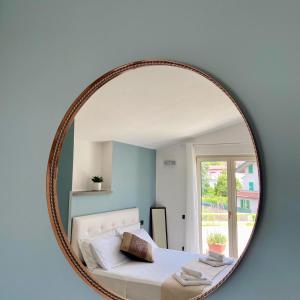 ein Spiegel, der ein Schlafzimmer mit einem Bett und einem Fenster reflektiert in der Unterkunft Mariposa in Telese