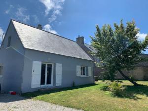 una casa blanca con un árbol en el patio en Maison Bord de Mer dans la Petite Irlande, en Auderville