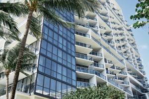 een hoog gebouw met palmbomen ervoor bij W South Beach in Miami Beach