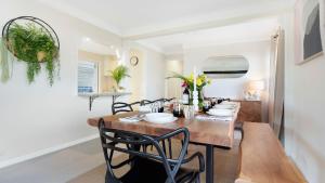 a dining room with a wooden table and chairs at Halcyon in Kiama