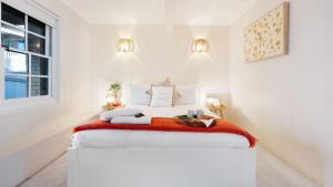 a bedroom with a bed with white walls and a window at Halcyon in Kiama
