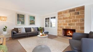 a living room with a couch and a fireplace at Halcyon in Kiama