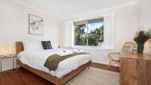 a bedroom with a large bed and a window at Halcyon in Kiama