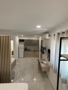 a room with a kitchen and a living room at Sunshine Apartments and Rooms in Nikiana