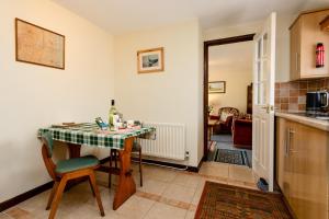 a kitchen with a table with a bottle of wine on it at Swallows Cottage nr Warkworth in Acklington +20 photos