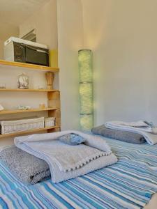 een slaapkamer met 2 bedden en handdoeken bij Maisonnette à la campagne. Idéal Télétravail in Éguilles