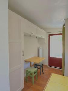 een kamer met een houten tafel en een groene kruk bij Maisonnette à la campagne. Idéal Télétravail in Éguilles