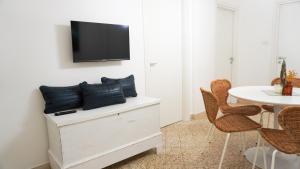 a living room with a tv on a wall with chairs at Donna Elena House in Maiori