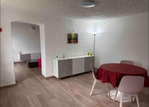a dining room with a red table and chairs and a room with a table at Rustico Campei in Medeglia