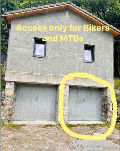 a building with two garage doors with a sign on it at Rustico Campei in Medeglia
