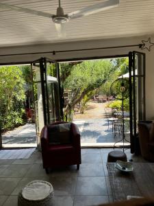 ein Wohnzimmer mit einem Stuhl und einer Glasschiebetür in der Unterkunft Maison 3 chambres avec piscine dans un jardin luxuriant in Puget-sur Argens