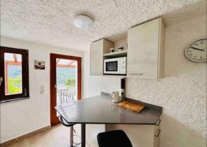 a kitchen with a table and a clock on the wall at Rustico Campei in Medeglia