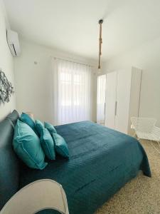 a bedroom with a large bed with blue pillows at Donna Elena House in Maiori
