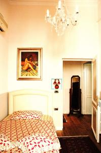 a bedroom with a bed and a chandelier at Charme Holidays Colosseum in Rome