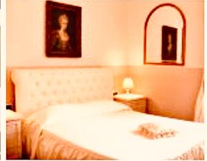 1 dormitorio con cama blanca y espejo en Charme Holidays Colosseum, en Roma