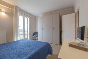 a bedroom with a blue bed and a desk with a computer at Casa Anna by HelloElba in Portoferraio
