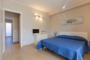 a bedroom with a blue bed and a television at Casa Anna by HelloElba in Portoferraio