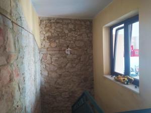 a room with a stone wall and a window at House Mare & Supramonte in Baunei +25 photos