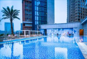 a swimming pool in a city with tall buildings at Zhuhai Marriott Hotel in Zhuhai