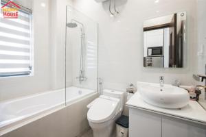a white bathroom with a toilet and a sink at Merry House Imperia in Hai Phong