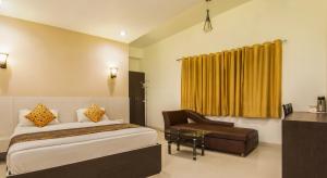 a hotel room with a bed and a chair at Hotel Metropolitan in Jaipur