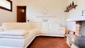 sala de estar con sofá blanco y chimenea en Sopravento Lake View- La Breva, en Dorio