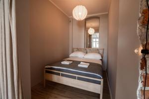 a small bed in a small room with a mirror at KING APART Gliniana 58 in Wrocław