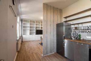a kitchen with a stainless steel refrigerator and wooden floors at KING APART Gliniana 58 in Wrocław