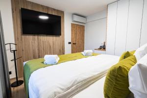 a bedroom with a large white bed with a flat screen tv at Penzion Monner in Mikulov