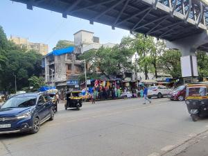 uma rua movimentada da cidade com carros e pessoas na rua em OSI Apartments Santacruz em Mumbai
