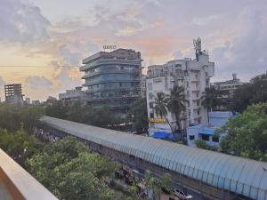 um comboio está estacionado numa cidade com edifícios em OSI Apartments Santacruz em Mumbai