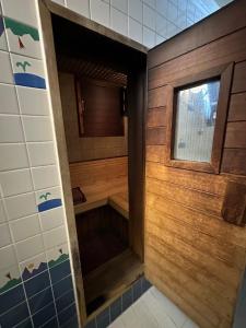 a walk in shower in a bathroom with wooden walls at ホテルロペ39 大人専用 in Nagoya