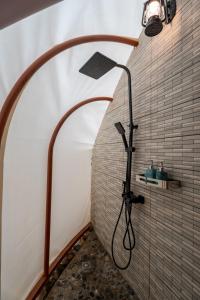 a bathroom with a shower with a shower head at Tớ Dày Du Già Village in Làng Cac