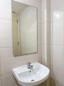 ein Badezimmer mit einem weißen Waschbecken und einem Spiegel in der Unterkunft Arva Home in Surabaya + 5 Fotos