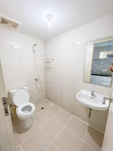 ein weißes Badezimmer mit Toilette und Waschbecken in der Unterkunft Arva Home in Surabaya