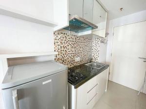 eine kleine Küche mit Herd und Spüle in der Unterkunft Arva Home in Surabaya