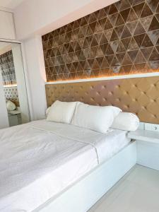 ein Schlafzimmer mit einem weißen Bett und einer braunen Wand in der Unterkunft Arva Home in Surabaya