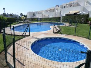 une piscine entourée d'une clôture dans l'établissement Apto El Palmeral Mojácar Playa, à Mojácar