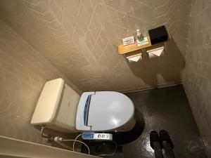 a bathroom with a toilet and a dispenser on the wall at ホテルロペ39 大人専用 in Nagoya