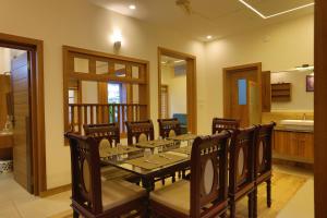 a dining room with a long table and chairs at Choice Beach House in Kannur